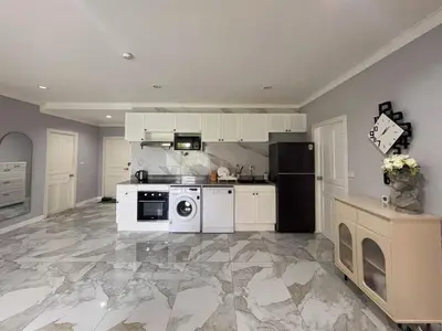 a large kitchen with a stove and a refrigerator at Green place condominium in Ban Lo Long