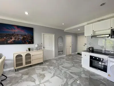 a kitchen with white cabinets and a marble floor at Green place condominium in Ban Lo Long