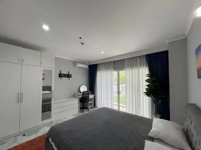 a bedroom with a bed and a desk and a window at Green place condominium in Ban Lo Long