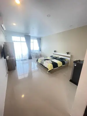 a bedroom with a bed and a flat screen tv at Nai-harn Apartments in Phuket Town