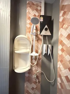 a shower in a bathroom with a hair dryer at Milos House in Ban Kata