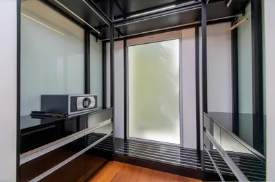 a room with a window and a clock on a shelf at Beachfront residence - just a step from the beach in Laguna Phuket