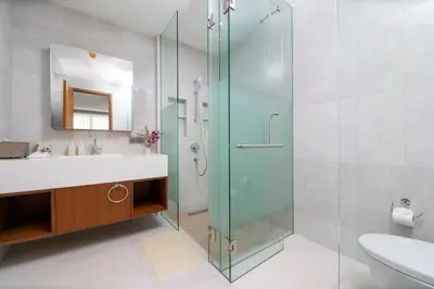 a bathroom with a glass shower and a sink at Beachfront residence - just a step from the beach in Laguna Phuket