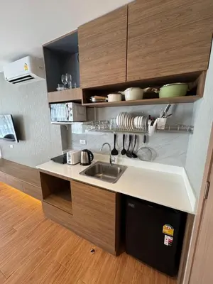 a kitchen with a sink and wooden cabinets at Apartment Naithon Wyndham in Nai Thon Beach