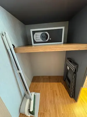 a room with a shelf with a microwave and a vacuum at Apartment Naithon Wyndham in Nai Thon Beach