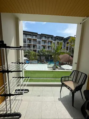 a balcony with a chair and a view of a pool at Apartment Naithon Wyndham in Nai Thon Beach