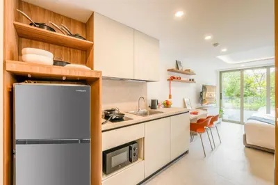 a kitchen with a sink and a refrigerator in a room at HOMA Chalong Bay in Ban Klang