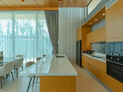 a kitchen with a counter and a table and chairs at Luxury 4BR Pool Villa in Botanica - Villa Boa in Ban Phru Champa