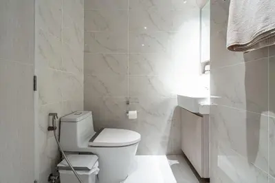 a white bathroom with a toilet and a sink at 1Bdr in Cassia Residence Laguna in Laguna Phuket