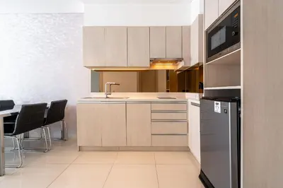a kitchen with white cabinets and a sink and appliances at 1Bdr in Cassia Residence Laguna in Laguna Phuket