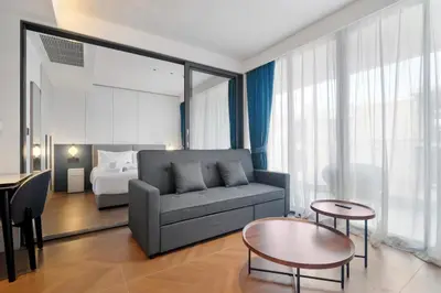 a living room with a couch and a bed at Beachfront 1 Bedroom 361 Condo Kora Resort in Phuket Town