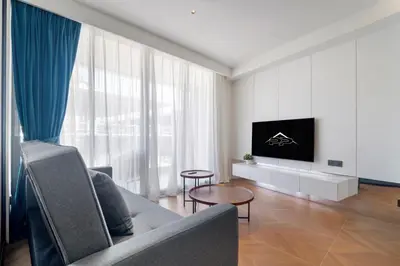a living room with a couch and a flat screen tv at Beachfront 1 Bedroom 361 Condo Kora Resort in Phuket Town