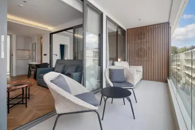 a living room with a couch and chairs on a balcony at Beachfront 1 Bedroom 361 Condo Kora Resort in Phuket Town