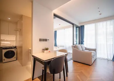 a kitchen and living room with a table and chairs at Kora Beachfront 240 One Bedroom Apartment Phuket in Phuket Town