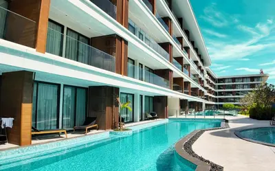 an external view of a building with a swimming pool at Kora Beachfront 240 One Bedroom Apartment Phuket in Phuket Town