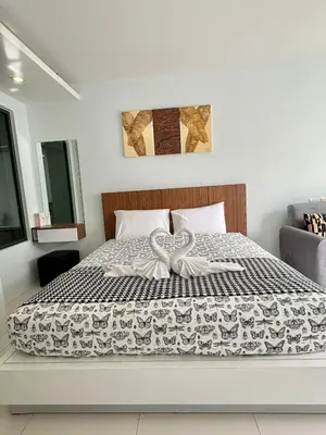 a bedroom with a bed with a bow on it at Modern 1 Bedroom Apartment - At The Tree Rawai in Rawai Beach