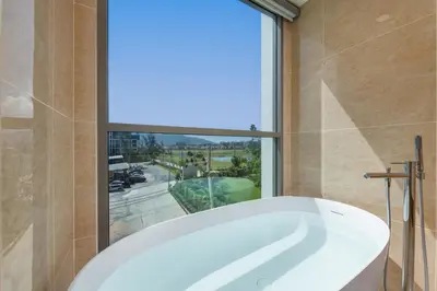 a bath tub in a bathroom with a large window at Suite Melos 2BR Pool Gym Access Ozone in Laguna Phuket