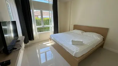 a bedroom with a bed with white sheets and a window at Holiday home in Ban Na Khua