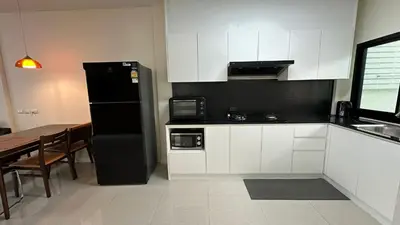a kitchen with a black refrigerator and a table at Holiday home in Ban Na Khua