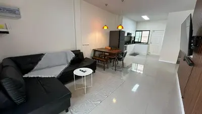 a living room with a black couch and a table at Holiday home in Ban Na Khua