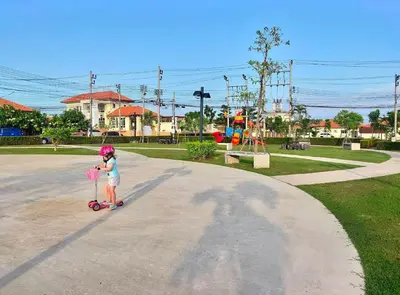 a little girl riding a scooter in a park at Holiday home in Ban Na Khua