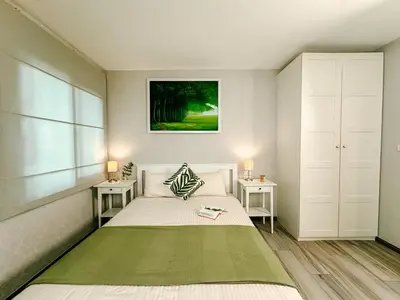 a bedroom with a large bed with two night stands at Cozy 1BR Tropical View at Title in Nai Yang Beach