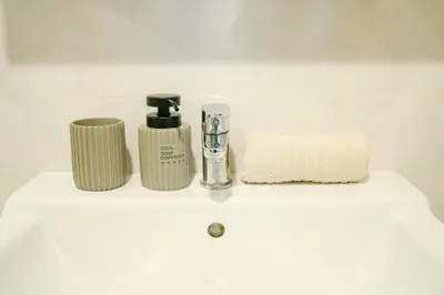 a bathroom sink with two soap dispensers on it at Cozy 1BR Tropical View at Title in Nai Yang Beach