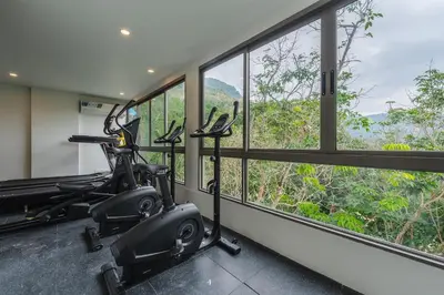 a gym with a exercise bike in a room with windows at C256 2BR Stay Close to Beach Rooftop Pool Views in Kamala Beach