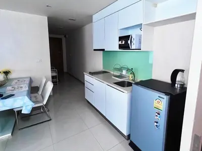 a kitchen with white cabinets and a blue refrigerator at Beachfront Patong Hillside Modern Apartment in Patong Beach