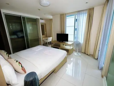 a hotel room with a large bed and a television at Beachfront Patong Hillside Modern Apartment in Patong Beach