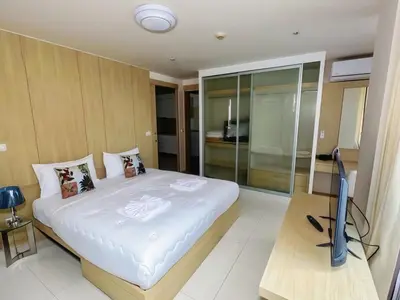 a bedroom with a bed and a television in it at Beachfront Patong Hillside Modern Apartment in Patong Beach