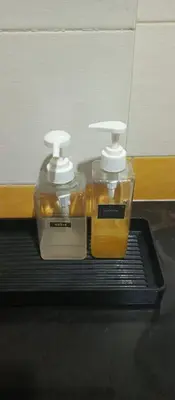 two bottles of honey sitting on a black tray at AP Apartment in Kathu