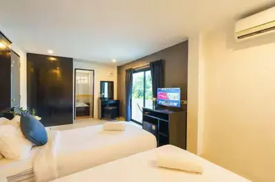 a hotel room with two beds and a television at AP Apartment in Kathu