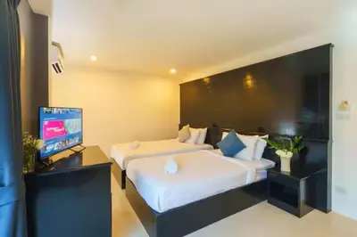 a hotel room with two beds and a flat screen tv at AP Apartment in Kathu