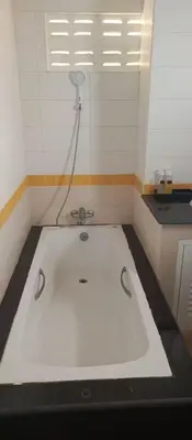 a bath tub with a shower in a room at AP Apartment in Kathu