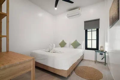 a white bedroom with a bed and a window at Modern Zen Oasis in Phuket in Ban Saiyuan (1)