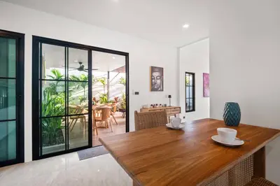 a dining room with a wooden table in a house at Modern Zen Oasis in Phuket in Ban Saiyuan (1)