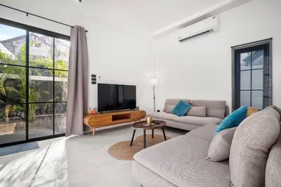 a living room with a couch and a tv at Modern Zen Oasis in Phuket in Ban Saiyuan (1)