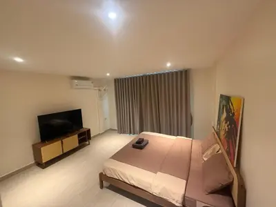 a hotel room with a bed and a flat screen tv at RK Boutique rooms in Patong Beach