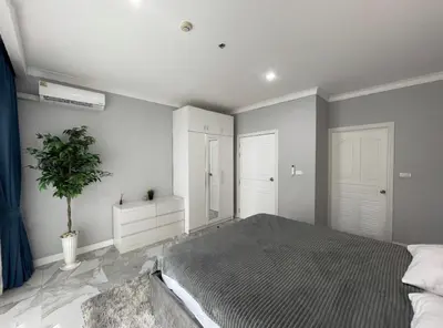 a bedroom with a bed and a plant in it at Phuket 402 in Phuket Town