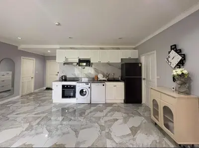 a kitchen with a stove and a refrigerator at Phuket 402 in Phuket Town