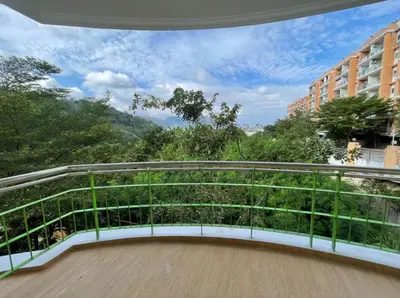 a balcony with a white and green railing and trees at Phuket 402 in Phuket Town