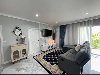 a living room with a couch and a tv at Phuket 402 in Phuket Town