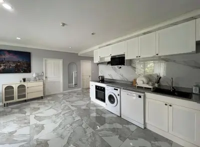 a kitchen with white cabinets and a stove top oven at Phuket 402 in Phuket Town