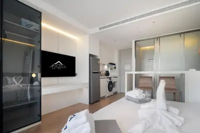 a white room with a bed and a television at Premier Pool View Studio 348 Kora Resort in Phuket Town