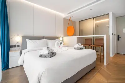 a bedroom with a white bed with two towels on it at Premier Pool View Studio 348 Kora Resort in Phuket Town