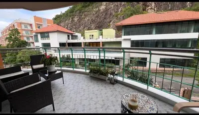 a balcony with chairs and a table and a building at Phuket 604 in Phuket Town