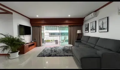 a living room with a couch and a television at Phuket 604 in Phuket Town