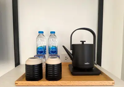 a tea kettle and two bottles of water on a table at Tatami Hotel Phuket in Ban Ket Ho