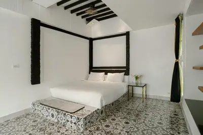 a bedroom with a white bed and a table at The Garden Escape Villa, Private Tropical Hideaway in Rawai Beach